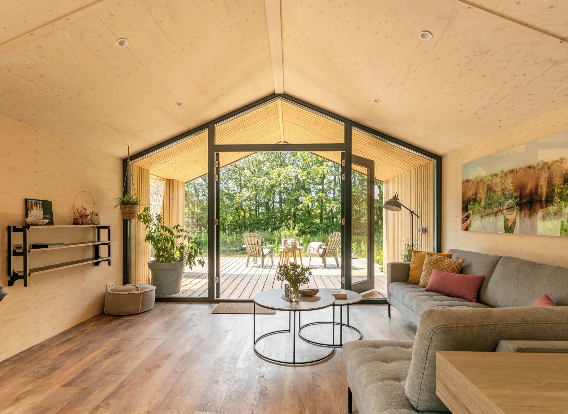 Lichte houten lodge met openslaande deuren naar het terras en de natuur